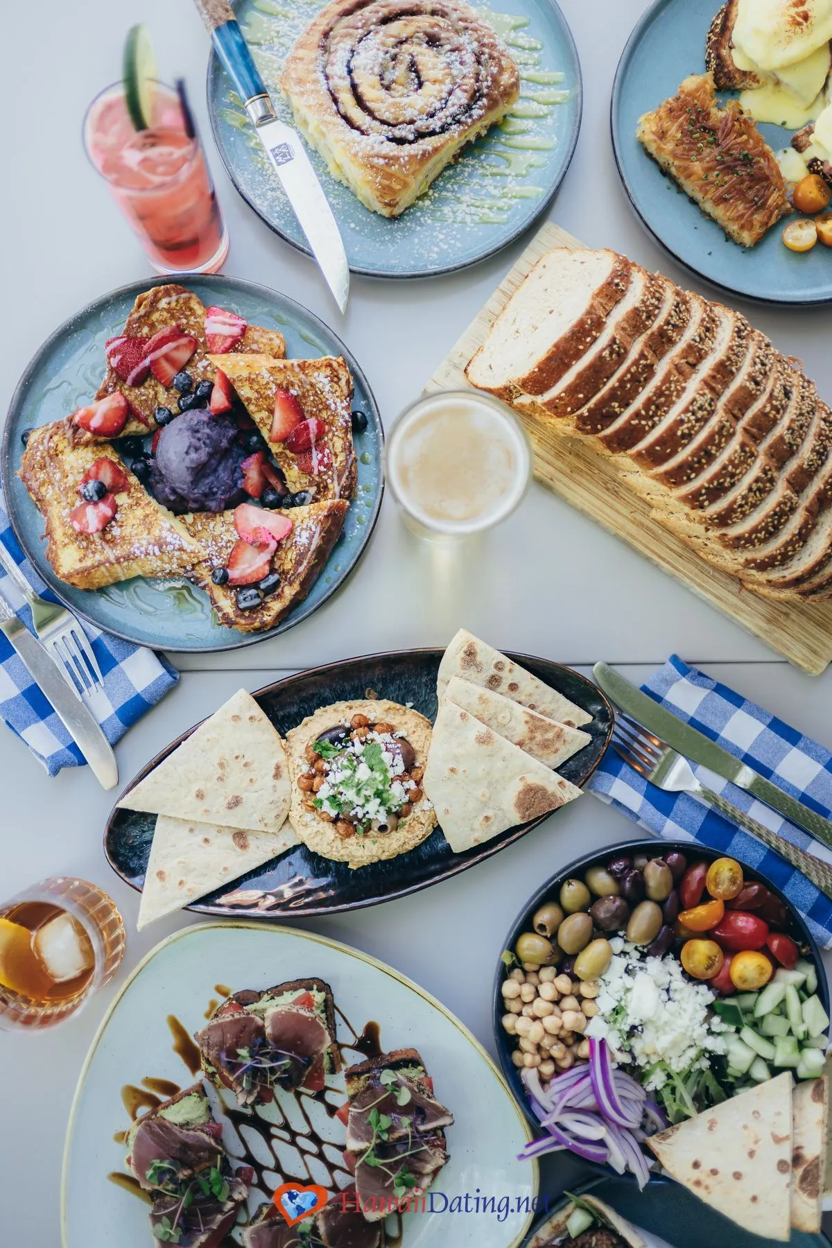 Brunch spread at Mala Ocean Tavern in Lahaina with French toast, a cinnamon bun, Greek salad, ahi bruschetta, and a hummus plate